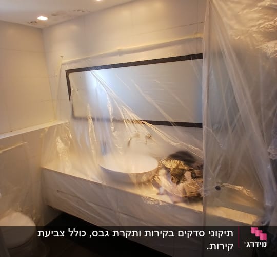 חדר אמבטיה מכוסה בניילון להגנה במהלך שיפוץ גבס